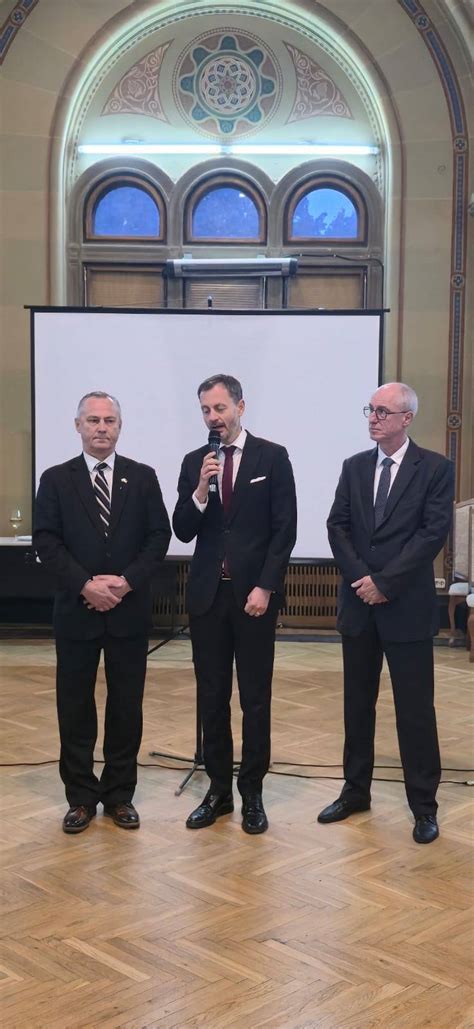 Mladý pár a rečník, ktorý prednáša príhovor s mikrofónom v slávnostnej sále