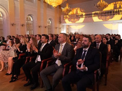 Osoba držiaca mikrofón hovorí k publiku na slávnostnej udalosti