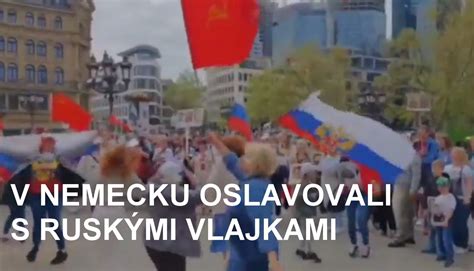 Tematické foto osláv Dňa víťazstva s ľuďmi mávajúcimi vlajkami
