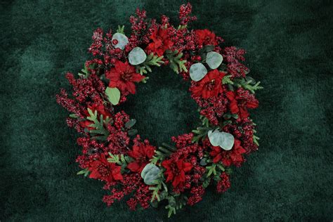 Fotografia: Červený vianočný veniec s girlandou na dverách