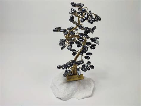 Schéma štruktúry stromčeka šťastia: kamenný podstavec, drôtené vetvičky a drahé kamene ako listy.