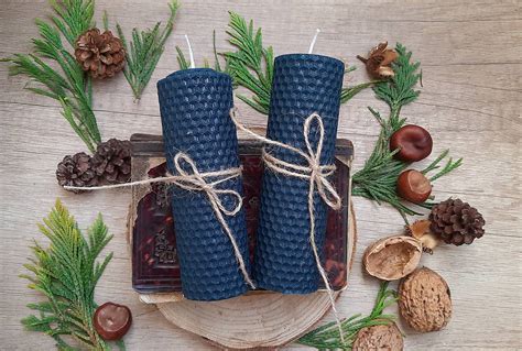 detailný záber na usporiadaný materiál: strieborné šišky, modré sviečky, jedľové vetvičky a tavnú pištoľ