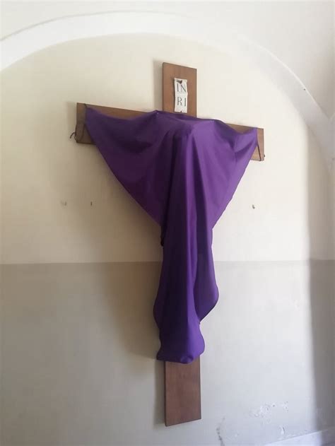 Zahalený kríž fialovým vélom v kostole počas pôstu, symbolizujúci kajúcnosť