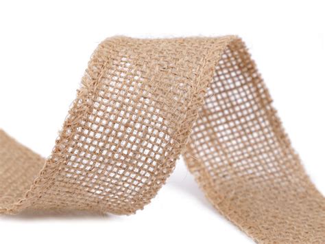 Detail stola so svadobnou výzdobou: jutová štóla, folklórna stuha, svietniky zo zaváraninových pohárov a kytica z lúčnych kvetov.