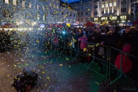 Dav ľudí na námestí počas vianočného koncertu s pódiom v pozadí