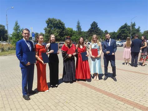 Tematická fotografia stužkovej slávnosti, študenti v spoločenských šatách s pripnutými zelenými stužkami