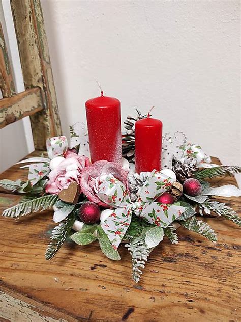 vianočný aranžmán na stole so sviečkami a čečinou