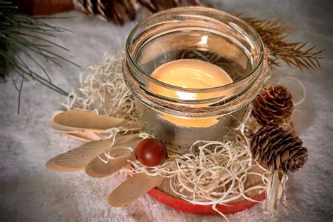 Diy sviečky v rôznych nádobkách s pridanými prvkami ako škorica alebo pomarančová kôra.