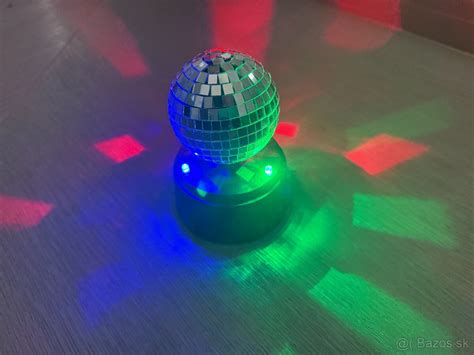 Disco guľa v akcii osvetľujúca tanečný parket farebnými lúčmi svetla