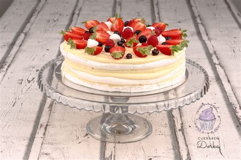 Pavlova torta ozdobená čerstvým ovocím a čokoládovým menom dieťaťa