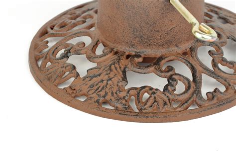 Detailný záber na zdobený liatinový stojan s rastlinnými ornamentmi pod vianočným stromčekom