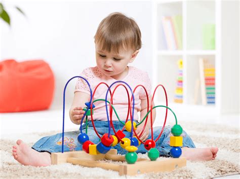 Dieťa sa hrá s farebným odrážadlom a ťahacou hračkou.