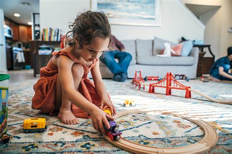 Chlapček sa hrá s dreveným vláčikom, dievčatko s bábikou.