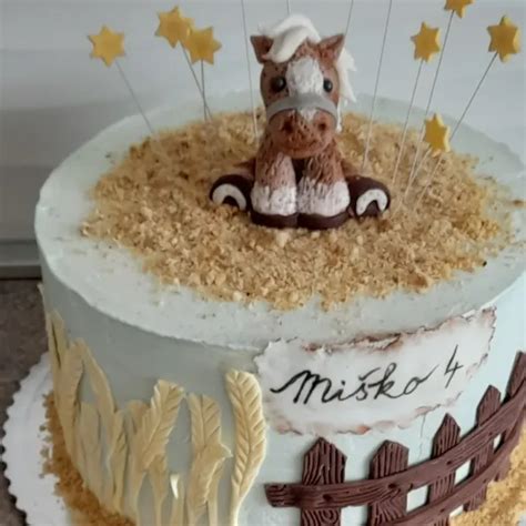 Detská torta zdobená marcipánovými zvieratkami a modrou stuhou