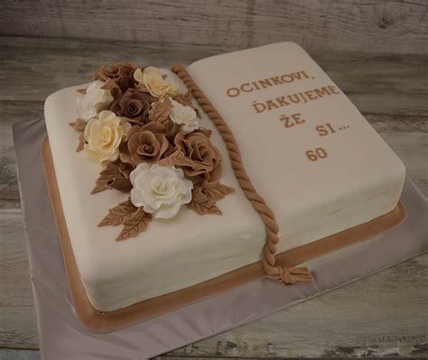 Torta v tvare otvorenej knihy s citátom z Biblie a ružencom ako dekoráciou, symbolizujúca duchovný význam prvého svätého prijímania.