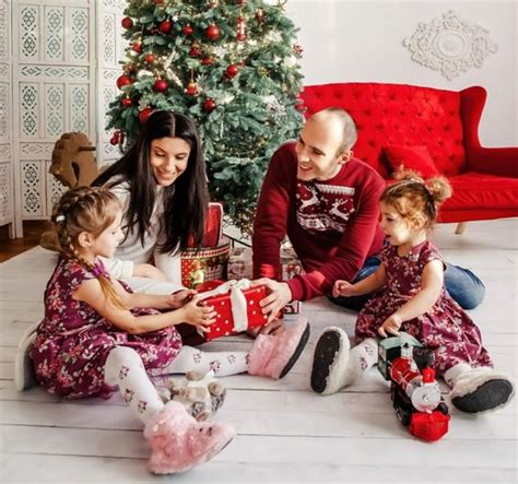 Tematické foto: Rodina pri rozbaľovaní vianočných darčekov pod stromčekom