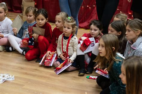 Skupina ľudí pri vianočnom stromčeku otvárajúca darčeky