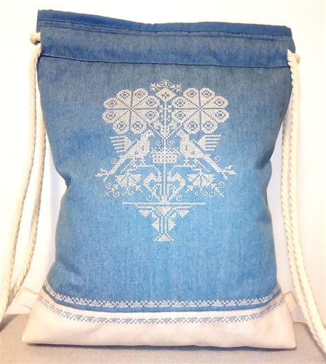 Detail výšivky na krstnej košieľke s ľudovým motívom a menom