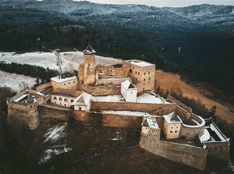 Fotografia Ľubovnianskeho hradu s drevenou dedinkou v popredí