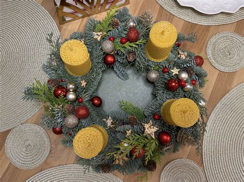 Ilustrácia adventného venca so štyrmi sviečkami, symbolizujúca prípravu na Vianoce.