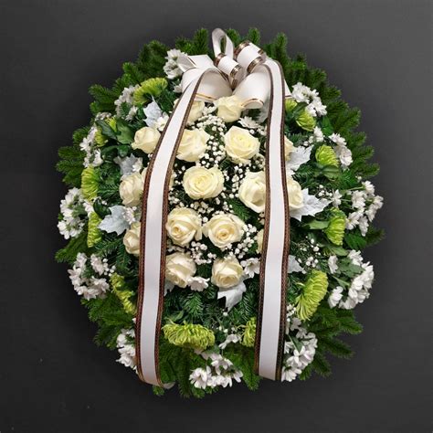 Fotografia smútočného venca s nápisom na stuhe.