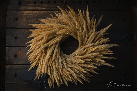 Štýlový veniec z prírodných tráv ozdobený jutovou stuhou.