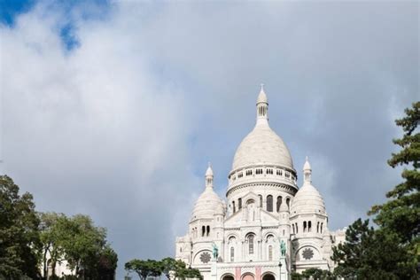 Muž v kostýme zajaca jazdí na snouborde v Paríži, v pozadí bazilika Sacre Coeur
