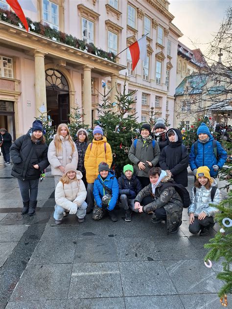 Ilustračné foto: skupina žiakov, rodičov a učiteľov usmievajúcich sa na vianočných trhoch