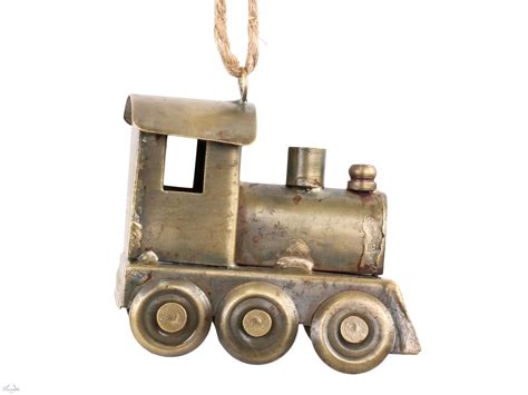 kompozícia vintage vianočných prvkov: vláčik pod stromčekom, miniatúrne dedinky, kovové svietniky