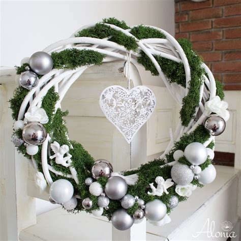 Závesný adventný veniec s malými vrecúškami alebo srdiečkami s číslami zavesenými na čečine, ozdobený šiškami a svetielkami