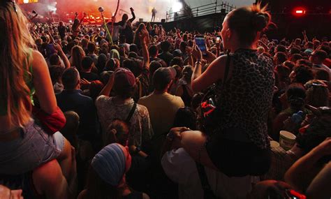 Energická fotografia z DJ setu na veľkom hudobnom festivale s davom ľudí