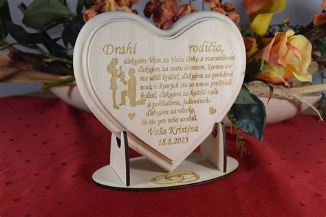 Svadobný pár odovzdávajúci drevené srdce rodičom