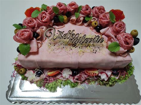 Detailné zdobenie slanej torty plátkami syra a údeninami.