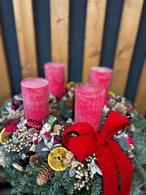 Adventný veniec s červenými mini vianočnými ružami a bielymi sviečkami