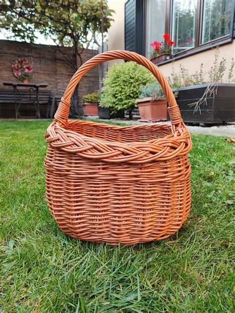 Košík z prútia s aranžovanou sviečkou, sušeným ovocím a vetvičkami