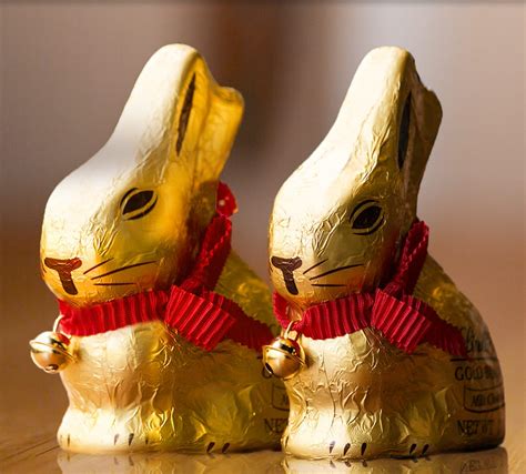 Lindt Zlatý Zajačik s červenou stuhou a zvončekom v trávnatej záhrade