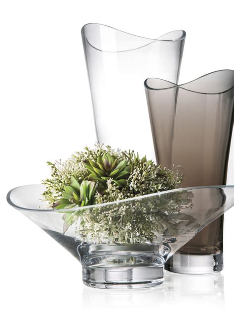 Detail stola s rustikálnou výzdobou: sklenené vázy, lúčne kvety, sviečky a drevené čísla stolov