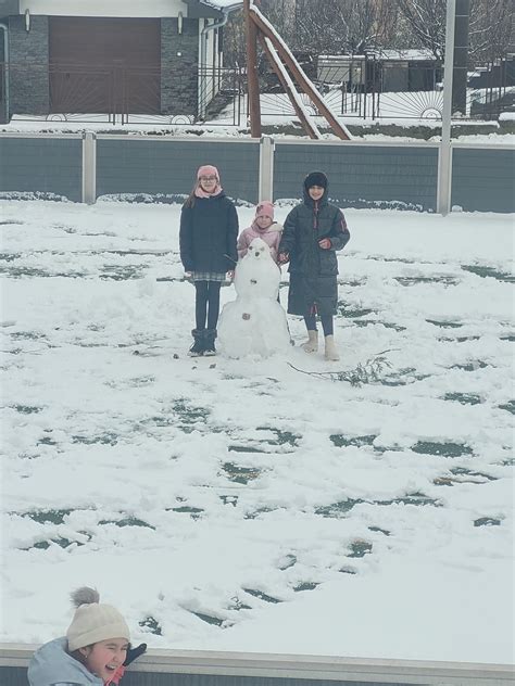 Rodina stavia snehuliaka v zasneženej záhrade