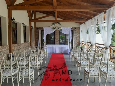 Stĺp vo svadobnej sále zdobený elegantnou drapériou z textilu v svadobných farbách
