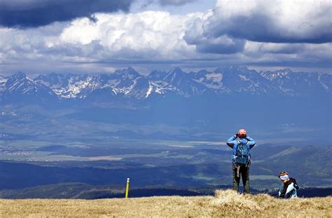 Rodina kráča po zasneženom chodníku v slovenskej prírode s výhľadom na hory
