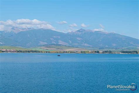 Panoramatický pohľad na zasneženú Liptovskú Maru s chatami a Nízkymi Tatrami v pozadí