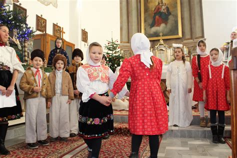Koledníci v tradičných kostýmoch vinšujú pred domom