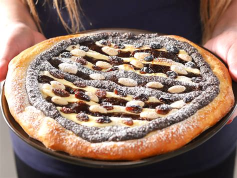 Vrstvený kysnutý koláč s lekvárovou priehlbinkou, potretý vajcom, pred vložením do rúry