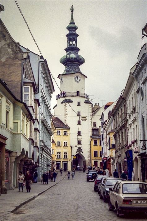 Zásnuby: tematická fotografia páru pod Michalskou bránou v Bratislave, muž kľačiaci s prsteňom