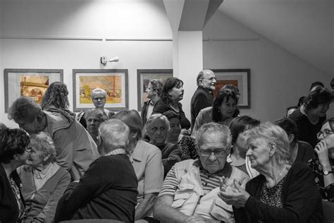 Fotografia z vernisáže výstavy, ľudia si prezerajú exponáty