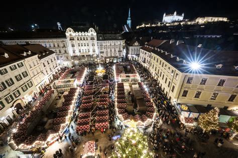 Snímka vianočných trhov na Námestí SNP s osvetlenými stánkami a vianočným stromčekom