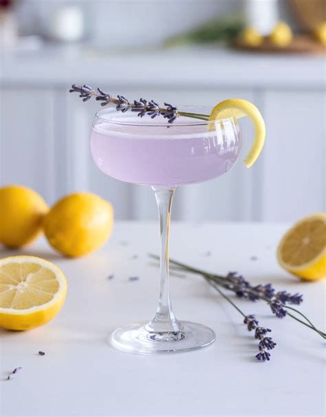 A beautifully presented lavender fizz cocktail with fresh flowers and berries
