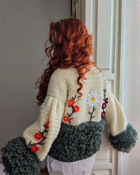 Blízky záber na textúru slávnostného kardiganu s lesklou niťou a jemnými aplikáciami.