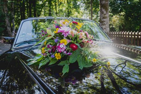 Detail kvetinovej girlandy a stúh na kapote svadobného vozidla