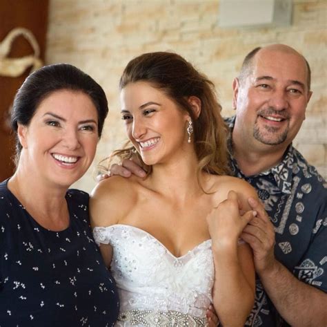 Tematické foto: Šťastní rodičia objímajúci novomanželov